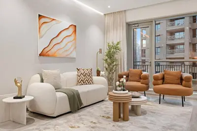 a living room with a white couch and two chairs at FIRST CLASS 2BR Incredible Burj Khalifa View in Dubai