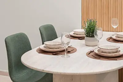 a wooden table with plates and wine glasses on it at FIRST CLASS 2BR Incredible Burj Khalifa View in Dubai