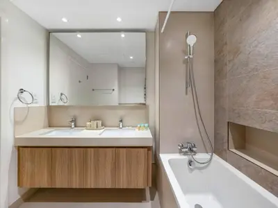a bathroom with a sink and a tub and a mirror at 2BR near Dubai Mall, Burj views! in Dubai