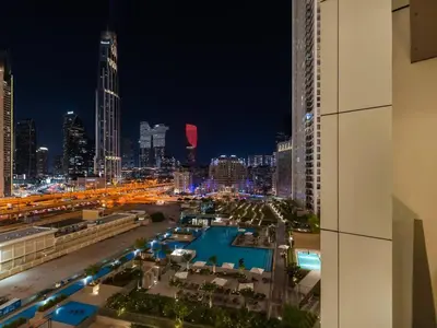 a view of a city at night with a pool at 2BR near Dubai Mall, Burj views! in Dubai