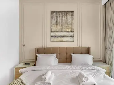 a bedroom with a large bed with white sheets at 2BR near Dubai Mall, Burj views! in Dubai