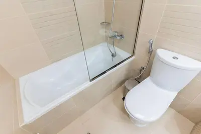 a bathroom with a shower and a toilet and a tub at JLT Studio apartment Goldcrest Executive in Dubai