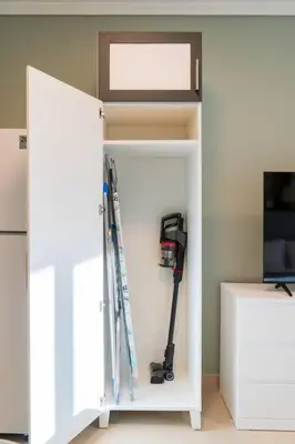 a white cabinet with skis and other equipment in it at JLT Studio apartment Goldcrest Executive in Dubai