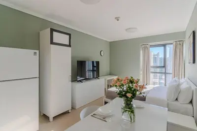 a living room with a couch and a table with flowers at JLT Studio apartment Goldcrest Executive in Dubai