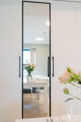 a dining room with a table and a mirror at JLT Studio apartment Goldcrest Executive in Dubai