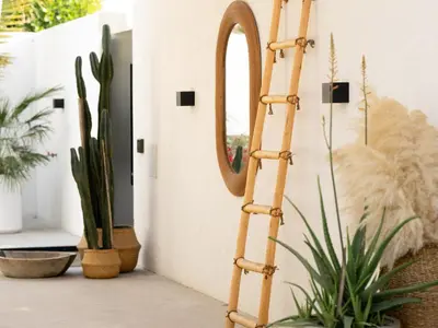 a bamboo mirror stand in a room with plants at Unique Beachside Studio, Shared Pool & Burj Khalifa View! in Dubai