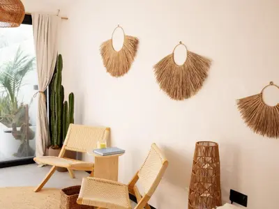 a living room with rattan chairs and a table at Unique Beachside Studio, Shared Pool & Burj Khalifa View! in Dubai