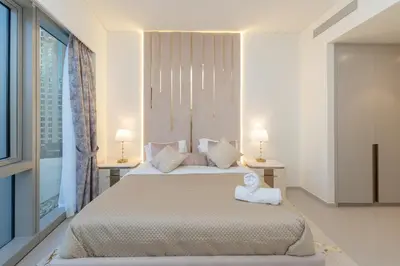a bedroom with two beds and two lamps and a window at Direct Burj Khalifa View I Minutes Walk to Dubai Mall I Stunning Fountain Views I One Lux Stay Grande Signature Residence in Dubai