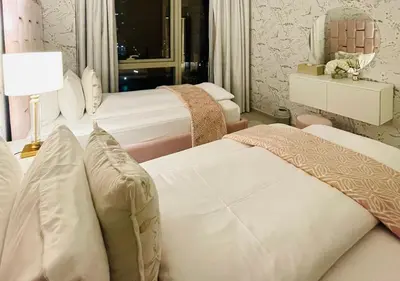 a bedroom with two beds and a lamp and a mirror at Direct Burj Khalifa View I Minutes Walk to Dubai Mall I Stunning Fountain Views I One Lux Stay Grande Signature Residence in Dubai