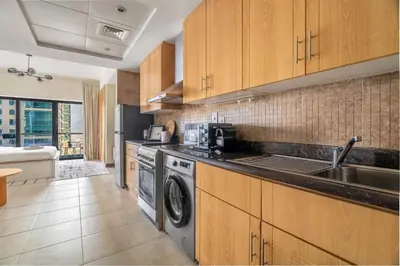 a kitchen with a sink and a washing machine at GuestReady - Stunning studio in JLT in Dubai