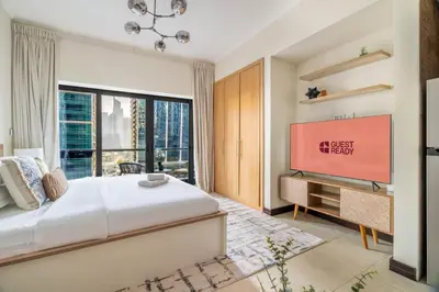 a bedroom with a large bed and a large window at GuestReady - Stunning studio in JLT in Dubai