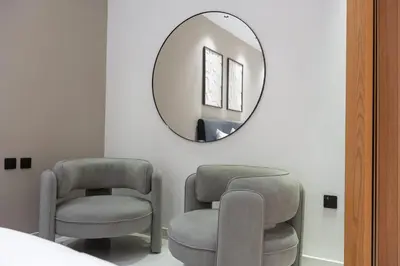 two chairs and a mirror in a room at StayShort - Luxurious 2-Bedroom Apartment perfect for families in Dubai Marina in Dubai