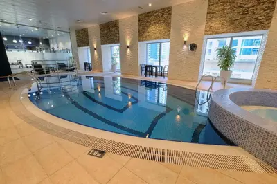 a large swimming pool in a large building at StayShort - Luxurious 2-Bedroom Apartment perfect for families in Dubai Marina in Dubai