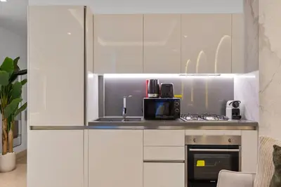 a kitchen with white cabinets and a counter with a microwave at Luxury Living Studio in the Heart of Business Bay in Dubai