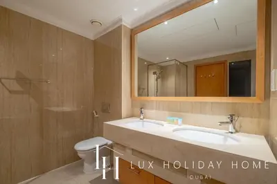 a bathroom with a sink and a toilet and a mirror at LUX The Shemara Marina View Suite in Dubai