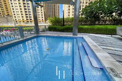 an empty swimming pool with buildings in the background at LUX The Shemara Marina View Suite in Dubai