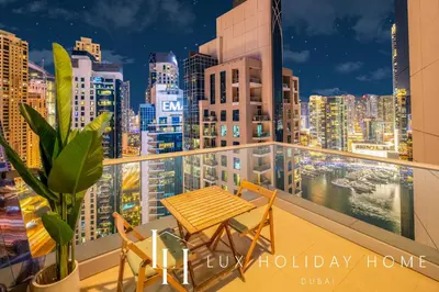 a balcony with a table and chairs and a city skyline at LUX The Shemara Marina View Suite in Dubai