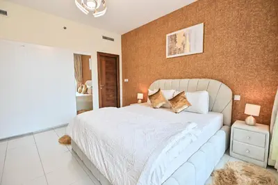 a bedroom with a white bed and a brown wall at Luxury 1 Bed with full Marina View - Emaar Park Island in Dubai