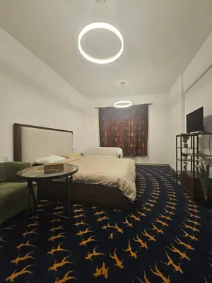 a bedroom with a bed and a table and a couch at Room with Kitchen Furnished Apartments by oima leasing property in Dubai