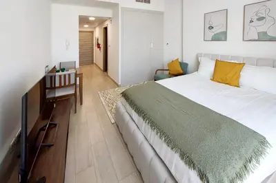 a bedroom with a large white bed and a desk at Bloom Tower C - JVC by Golden Casa in Dubai