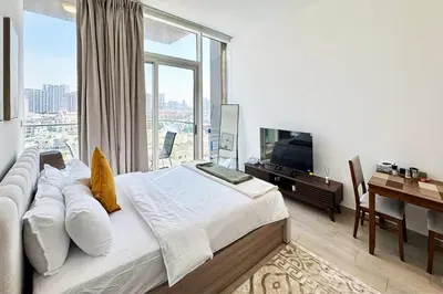 a bedroom with a bed and a large window at Bloom Tower C - JVC by Golden Casa in Dubai