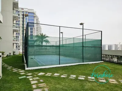 a tennis court with a net on the grass at Blissful One Bedroom Apartment in Dubai