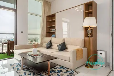a living room with a couch and a table at Blissful One Bedroom Apartment in Dubai
