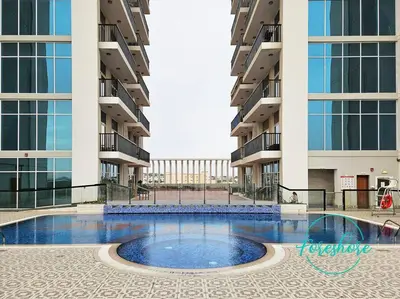 a large swimming pool in the middle of a building at Blissful One Bedroom Apartment in Dubai