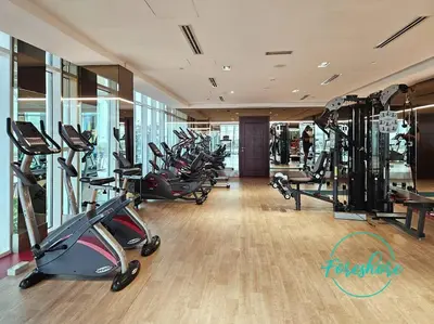 a gym with a bunch of treadmills and exercise bikes at Blissful One Bedroom Apartment in Dubai