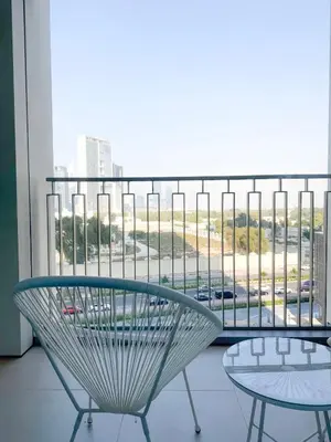 a chair and a table on a balcony with a view at INA HOMES - 1BHK Downtown Views Direct Access to Dubai Mall in Dubai
