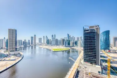 a view of a river in a city with tall buildings at Spacious Studio with Pool - Canal & Burj Views in Dubai