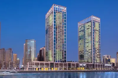 two tall skyscrapers in a city next to the water at Spacious Studio with Pool - Canal & Burj Views in Dubai