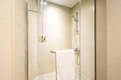 a bathroom with a shower with a glass door at Spacious Studio with Pool - Canal & Burj Views in Dubai