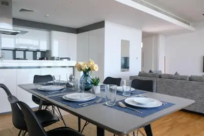 a dining room table with chairs and a kitchen at Mira Holiday Homes - Luxury 1 bedroom with sea view in Dubai