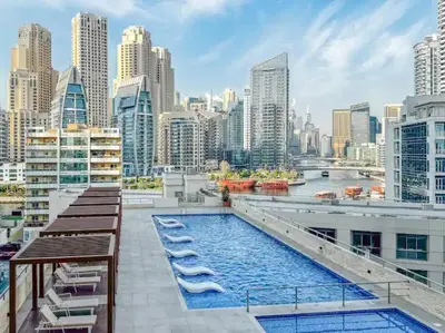 a pool on the roof of a building with a city skyline at Royal Marina Experience Lavish 2BR Waterfront View in Dubai