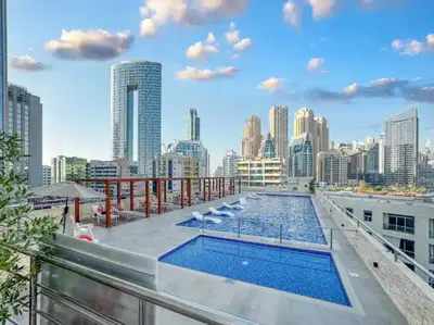 a pool on the roof of a building with a city skyline at Royal Marina Experience Lavish 2BR Waterfront View in Dubai