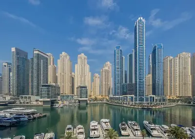 a view of a city with boats in a harbor at Royal Marina Experience Lavish 2BR Waterfront View in Dubai