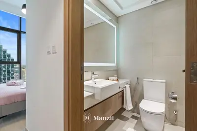 a bathroom with a sink and a toilet and a bed at 1BR Apt Near Downtown Dubai with Pool & Skyline Views in Dubai