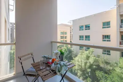 a table on a balcony with a view of a building at Frank Porter - Al Samar 1 in Dubai
