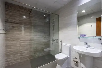 a bathroom with a toilet and a sink and a shower at Livbnb - 2B Maid's in Dunya, 5Min Walk to Dubai Mall in Dubai