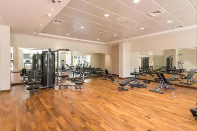 a gym with lots of treadmills and exercise bikes at Livbnb - 2B Maid's in Dunya, 5Min Walk to Dubai Mall in Dubai