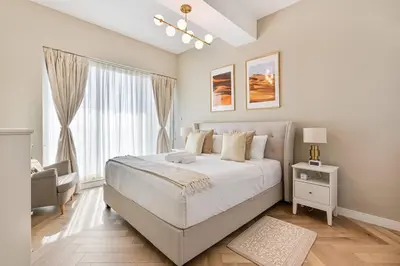 a white bedroom with a large bed and a window at Urban Oasis 1BR in Armada with Cityscape Views in Dubai