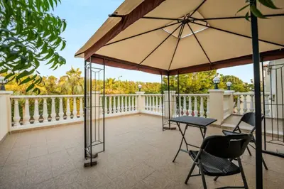 a balcony with a table and chairs and an umbrella at Beautiful 2BR Villa in JVT in Dubai