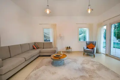 a living room with a couch and a table at Beautiful 2BR Villa in JVT in Dubai