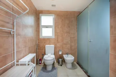 a bathroom with a toilet and a sink and a shower at Beautiful 2BR Villa in JVT in Dubai
