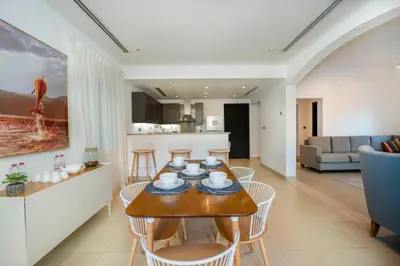 a dining room and living room with a table and chairs at Beautiful 2BR Villa in JVT in Dubai
