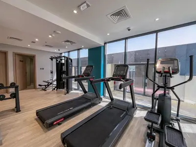 a gym with treadmills and elliptical machines at Elegant Studio in Azizi Riviera with Luxury Amenities in Dubai