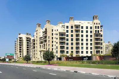 a large white building on the side of a road at Asayel Apartments in Dubai