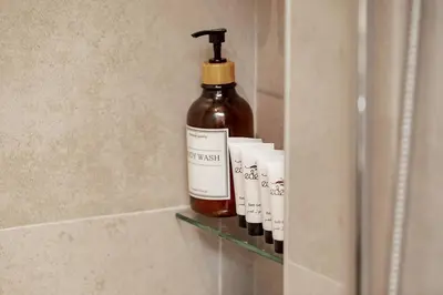 a bottle of soap sitting on a shelf in a bathroom at Asayel Apartments in Dubai