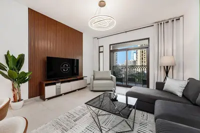 a living room with a couch and a tv at Asayel Apartments in Dubai